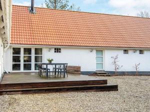 a table and chairs on a wooden deck in front of a house at Holiday home Allingåbro XXIV in Allingåbro