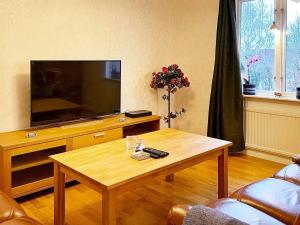 a living room with a television and a coffee table at Holiday home SÖLVESBORG XVI in Sölvesborg