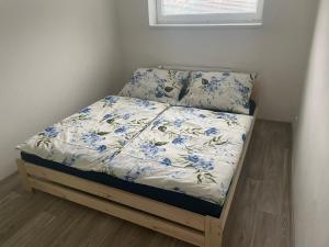 ein Bett in einem Zimmer mit blauen Blumen darauf in der Unterkunft V uličce in Velké Losiny