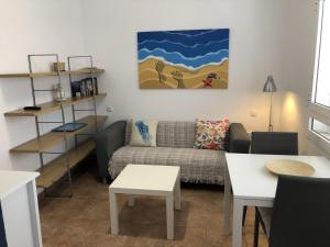 a living room with a couch and a table at La casa de la playa in Tarajalejo