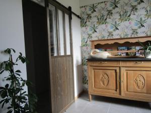 uma cozinha com um armário de madeira ao lado de um lavatório em chez LISON, HEBERGEMENT DE CHARME EN MADIRAN 