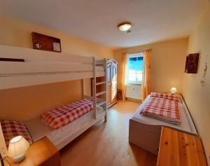 a bedroom with two bunk beds and a window at Ferienwohnung Böck, Wengen im Allgäu in Weitnau