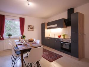 een keuken met een houten tafel en witte stoelen bij Ferienwohnung Böck, Wengen im Allgäu in Weitnau