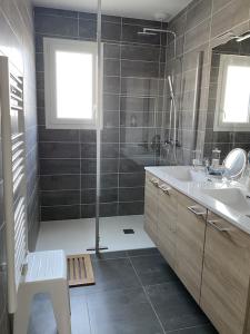 ein Badezimmer mit einem Waschbecken, einem Spiegel und einer Badewanne in der Unterkunft new architect villa with large terrace and patio 800 m from the sea in Vaux-sur-Mer