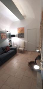 un soggiorno con un divano e una sedia di Palazzo Saraceno apartments-Antica mangiatoia a Taranto Altre 16 foto
