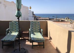 タラハレホにあるLa casa de la playaの海を望むバルコニー(椅子2脚、パラソル1本付)