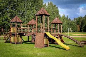 a wooden playground with a slide and a slideintend at Atpūtas un sporta komplekss Mednieki - atpūta dabā, pie ezera in Salainis +65 photos