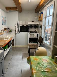 una cucina con tavolo e piano di lavoro di Chambres papillon a La Neuveville