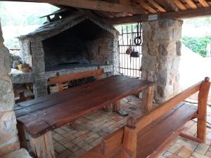 a wooden bench in front of a stone fireplace at Sage House in Trpanj