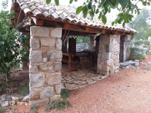 un edificio in pietra con un tavolo in legno di Sage House a Trpanj (Trappano)