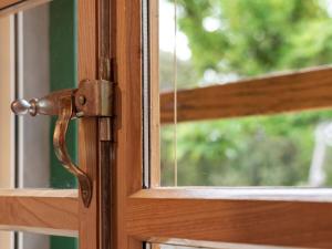 una porta di legno con un chiavistello arrugginito su una finestra di Sage House a Trpanj (Trappano)