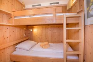 łóżko piętrowe w drewnianym pokoju w obiekcie Appartement Wiesberger 62 Top 6 w mieście Königsleiten
