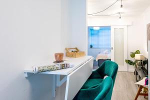 een woonkamer met een bureau en een groene stoel bij Haygarth Apartment in Knebworth