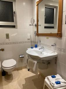 a bathroom with a sink and a toilet and a mirror at Paradise Bay Resort in Mellieħa