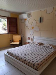 um quarto com uma cama grande e uma parede de flores em Maison MANZÈL à St Esprit - 20 min des plages em Grande Savane
