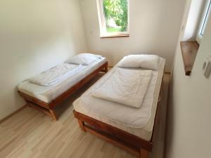 two beds in a small room with a window at Camping Karolina in Planá +41 photos