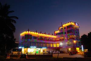 een groot gebouw met 's nachts verlichting bij The Rosetta Castle in Kalpatta