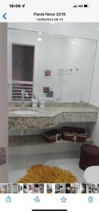 ein Badezimmer mit einer Theke mit einem Waschbecken und einem Teppich in der Unterkunft Residencial a Beira Mar Pero in Cabo Frio