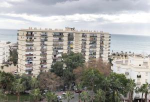 an apartment building with people on the balconies and the ocean at Sunny Suites Jupiter Apartments in Benalmádena