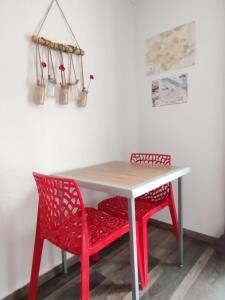 a table with two chairs and a red table and chairs at Studio Les coquelicots in Saint-Romain-sur-Cher