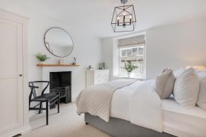 - une chambre avec un lit, une chaise et un miroir dans l'établissement Weavers Cottage, Sleeps 4, town centre, à Kirkby Lonsdale
