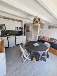 uma cozinha e uma mesa e cadeiras num quarto em Appartement au bord de mer em Carnac