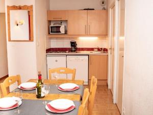 una cucina con tavolo e sedie e una cucina con sala da pranzo di Appartement Puy-Saint-Vincent, 3 pièces, 6 personnes - FR-1-504-599 a Puy-Saint-Vincent