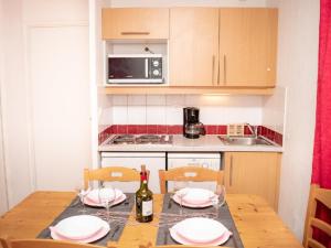 a kitchen with a table with plates and a bottle of wine at Appartement Puy-Saint-Vincent, 3 pièces, 6 personnes - FR-1-504-613 in Puy-Saint-Vincent