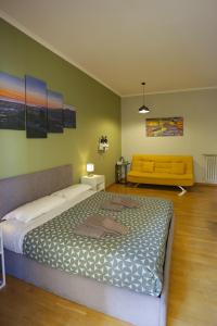 a bedroom with a large bed and a yellow couch at Vomero Maison in Naples