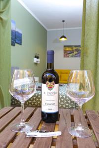 eine Flasche Wein und zwei Weingläser auf einem Holztisch in der Unterkunft Vomero Maison in Neapel