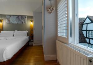 a bedroom with a bed and a large window at Talbot Lane Cottage Horsham By My Getaways in Horsham