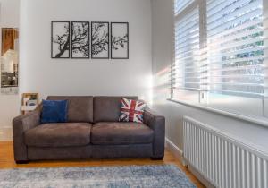 sala de estar con sofá y ventana en Talbot Lane Cottage Horsham By My Getaways, en Horsham