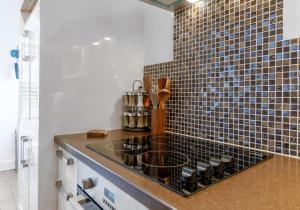 a kitchen with a sink and a tile wall at Talbot Lane Cottage Horsham By My Getaways in Horsham +25 photos
