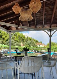 a patio with a table and chairs and a pool at Palladium Hotel in Kriopigi