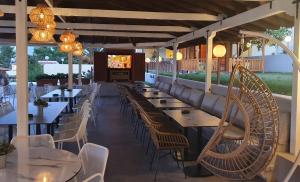 a restaurant with tables and chairs and a television at Palladium Hotel in Kriopigi