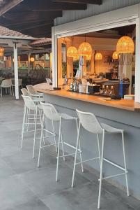 a bar with white bar stools in a restaurant at Palladium Hotel in Kriopigi