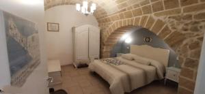 una camera con un letto in un muro di mattoni di Palazzo Saraceno apartments-Antica mangiatoia a Taranto