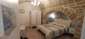 una camera da letto con un letto in un muro di mattoni di Palazzo Saraceno apartments-Antica mangiatoia a Taranto