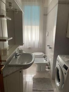 リド・ディ・イエゾロにあるAppartamento Ellidorの白いバスルーム(洗面台、トイレ付)