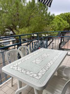 a white table and chairs on a balcony at Appartamento Ellidor in Lido di Jesolo