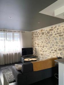 uma sala de estar com um sofá e uma parede de pedra em Maison plein centre ville La Roche Sur Yon em La Roche-sur-Yon