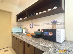 a kitchen counter with a microwave and a sink at Afamosa Villa with private pool by BeeStay in Kampong Alor Gajah
