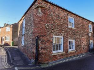 um edifício de tijolos com janelas brancas numa rua em 1 Bishopgate Court em Goole