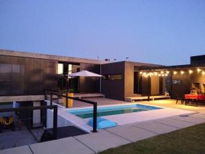 una casa con piscina frente a ella en BLOCK HOUSE en San Antonio de Arredondo