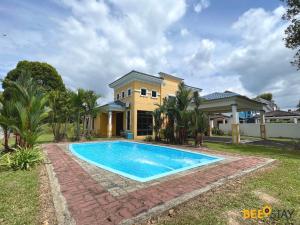 a house with a swimming pool in front of a house at Afamosa Villa with private pool by BeeStay in Kampong Alor Gajah