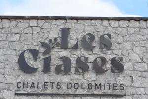 una señal en el costado de una pared de piedra en Les Ciases Chalets Dolomites, en San Vigilio Di Marebbe