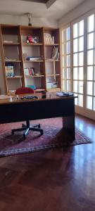 a desk with a chair in a room with shelves at B&B Villa Victoria in Ragusa