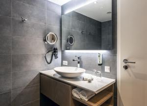 ein Bad mit einem Waschbecken und einem Spiegel in der Unterkunft Karma Bavaria in Schliersee