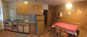 a kitchen with a stove and a sink and a table at Appartamento Cogolo con terrazza in Cogolo