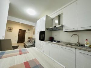 una cucina con armadi bianchi e lavandino di Luxury New Apartments Centru a Iaşi